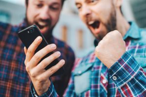 Two,Friends,Looking,Extremely,Excited,Getting,Good,News,Winning,A